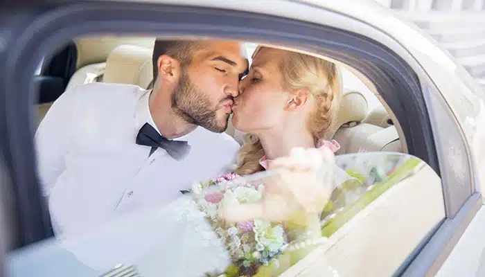 wedding couple kissing in rented car